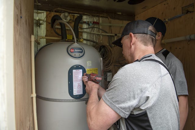 Petersen Plumbing works on a water heater.